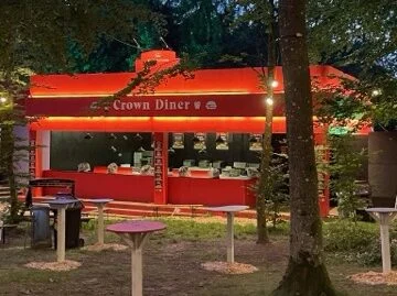 Den røde Crown Diner-madvogn mellem træerne